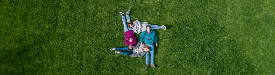 Una familia disfruta de la naturaleza tumbados sobre la hierba